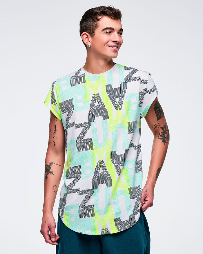Longline cap-sleeve top with an all-over “ZUMBA” letter print in aqua, lime, and gray on a white base, worn by a male model with teal jogger pants.