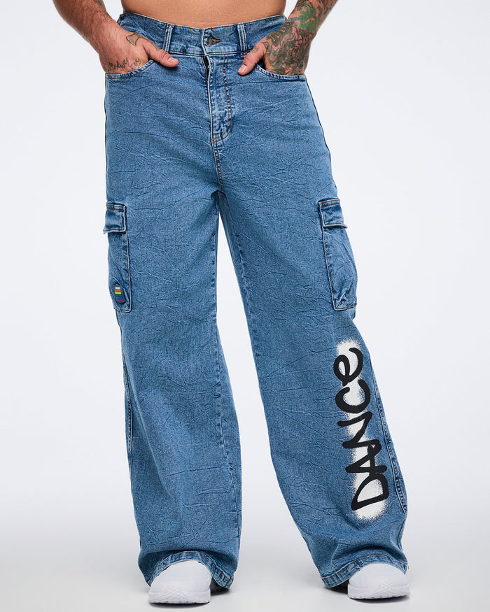 Male model wearing wide‑leg denim cargo pants with “DANCE” on the leg, standing against a white background.