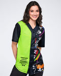 Female model wearing a neon green and black graphic Zumba jersey with multicolor accents on a white background.