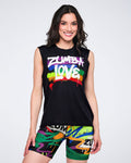 Female model wearing a black sleeveless top with 'Zumba Love' text over a rainbow pattern, paired with colorful shorts on a white background.