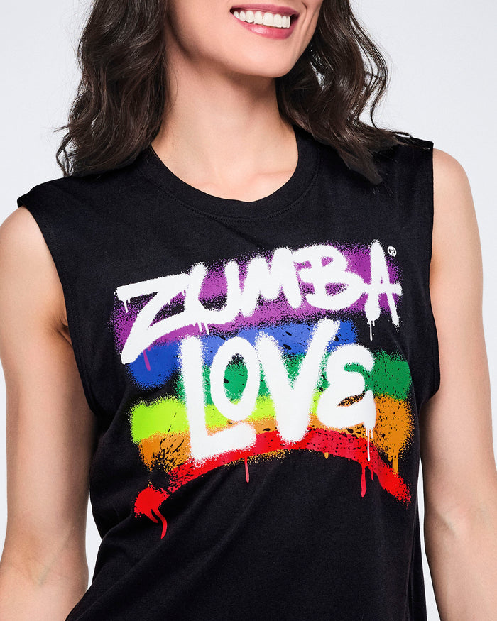 Close-up of a female model wearing a black sleeveless shirt with 'Zumba Love' in white, with a rainbow spray-painted pattern, all against a white background.