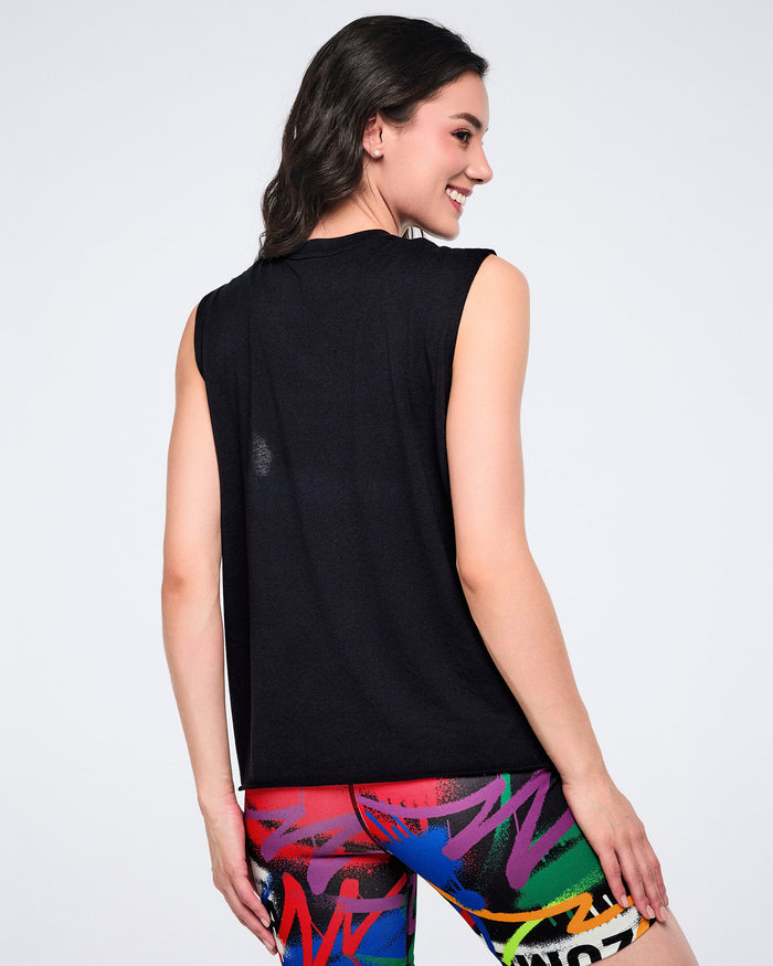 Back view of a female model wearing a black sleeveless top and colorful biker shorts on a white background.
