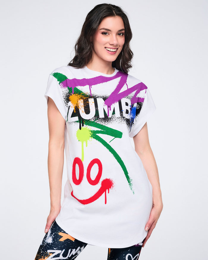Female model wearing a white t-shirt with colorful graphics and text on a white background.
