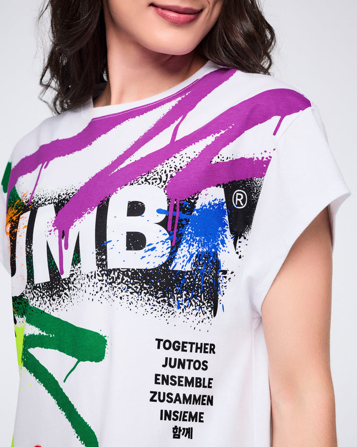 Close-up view of a female model wearing a white t-shirt with colorful graphics and text on a white background.