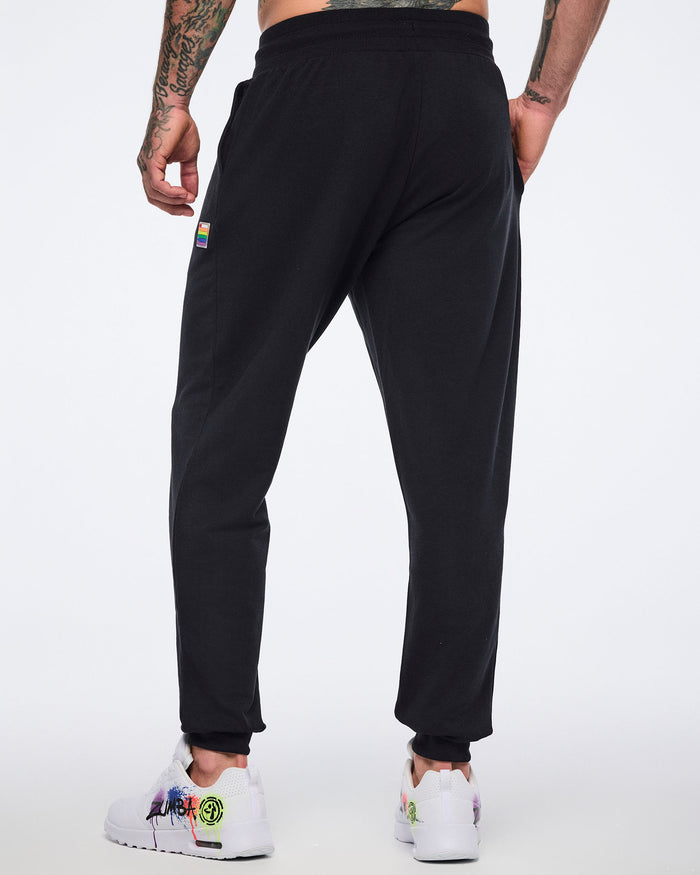 Male model showing the back of the black jogger pants on a white background.