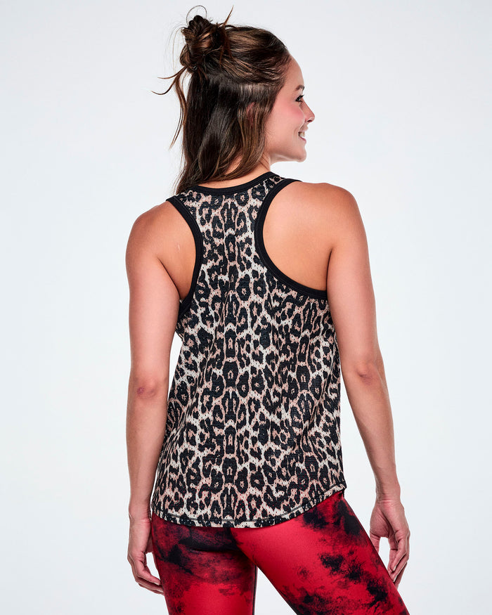 Back view of a female model wearing a basketball tank top with a black, beige, and white leopard print pattern, paired with red and black leggings.