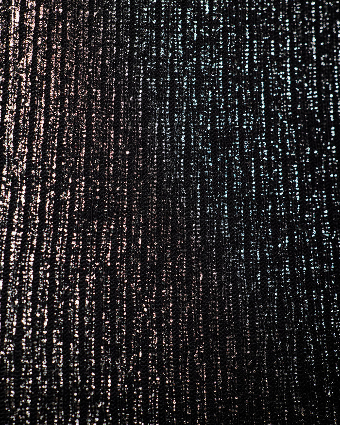 A close-up of a textured black fabric with vertical metallic silver and bronze shimmering streaks.