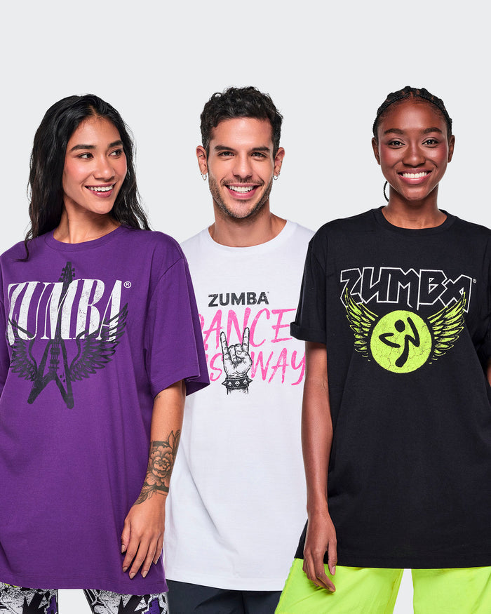 Three models wearing Zumba graphic t-shirts in purple, white, and black, standing against a white studio background.