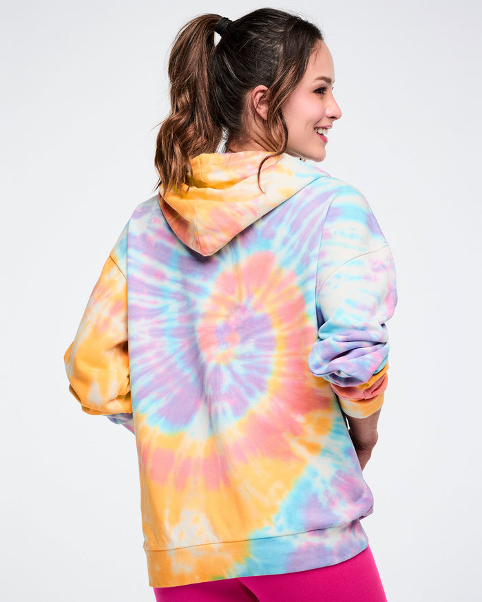 Back view of a female model wearing a tie-dye Zumba hoodie.