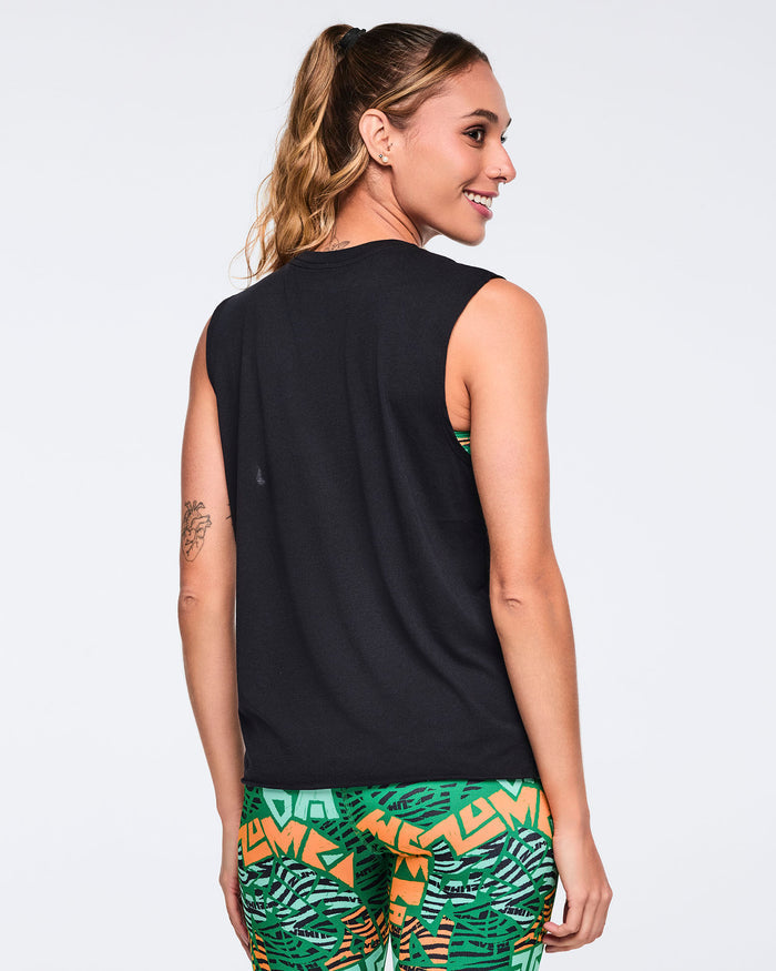 Back view of a black sleeveless tank top with a crew neckline, straight hem, and relaxed fit. Female model wears the top with green, orange, and black abstract print leggings, shown from the back with her hair in a high ponytail.