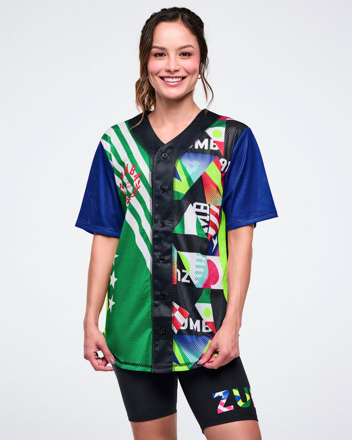 Female model wearing a colorful sports jersey with various patterns on a white background.