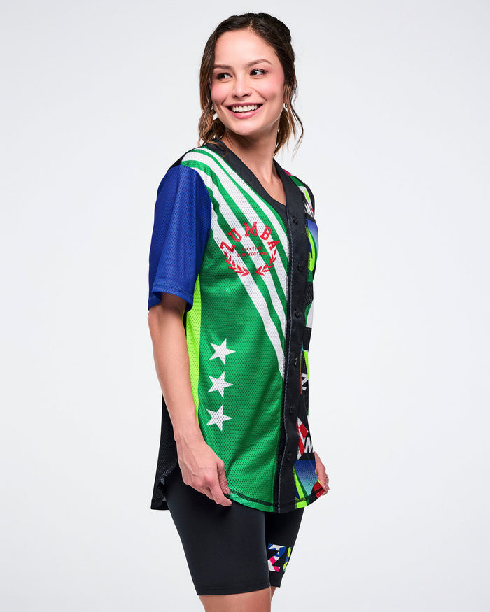 Female model wearing a colorful sports jersey with a white background.