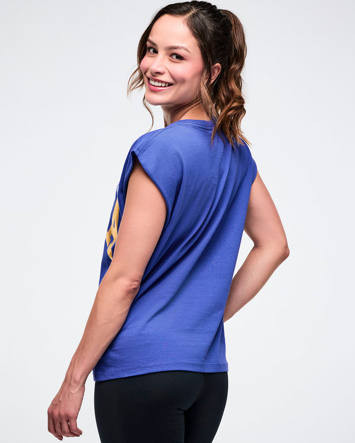 Back view of a female model in a blue shirt and black leggings on a white background.