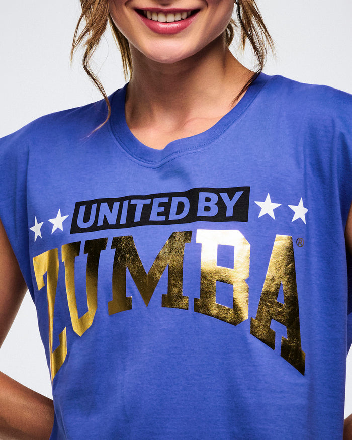 Close-up of a female model wearing a blue t-shirt with 'UNITED BY ZUMBA' text.