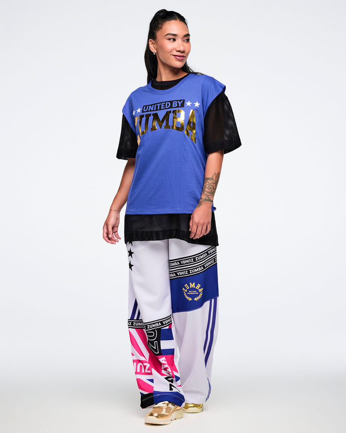 Female model wearing a blue and black outfit with 'Zumba' branding on a white background.