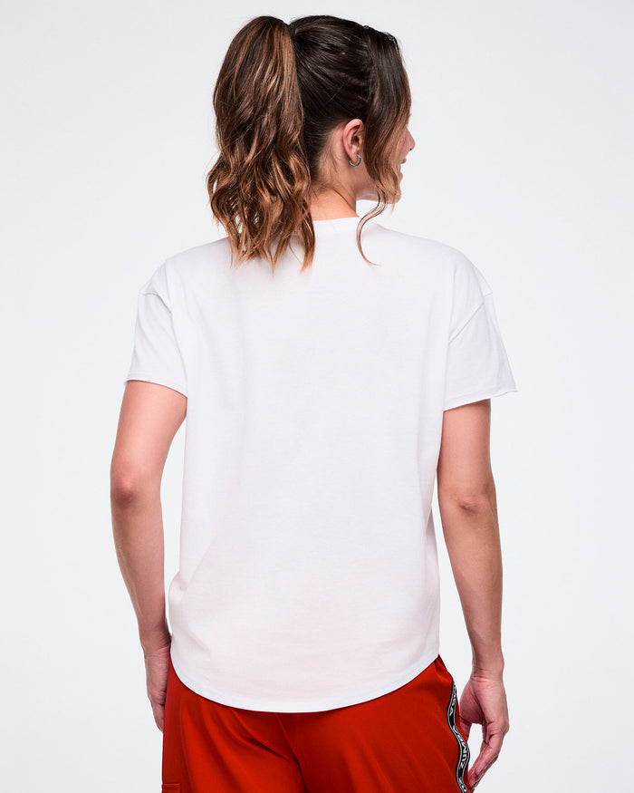 Back view of a female model wearing a white t-shirt and red shorts.