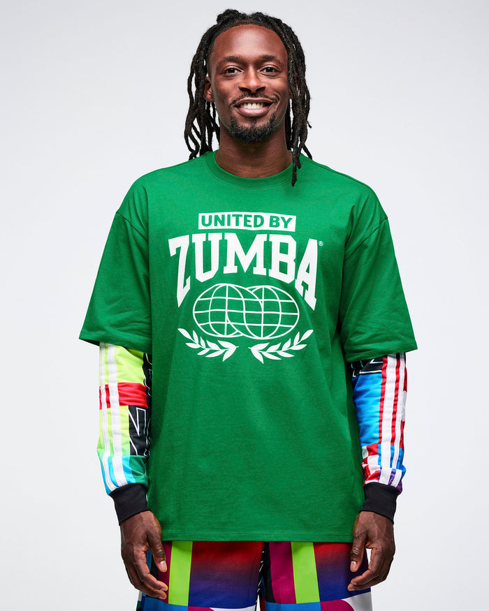 Male model wearing a green Zumba t-shirt over a shirt with colorful sleeves on a white background.