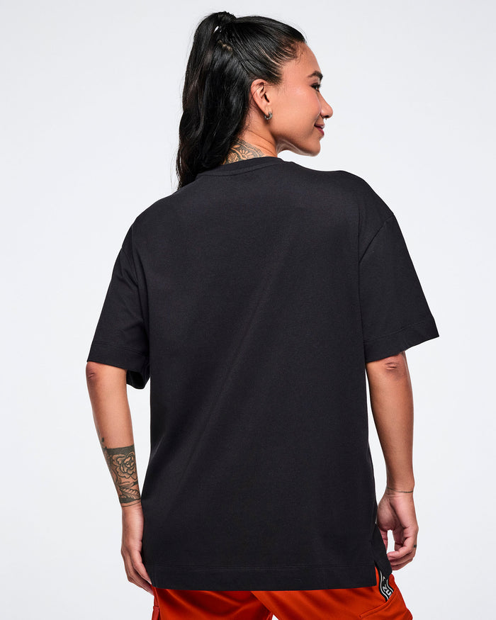 Female model, shown from behind. wearing a black t-shirt on a white background.