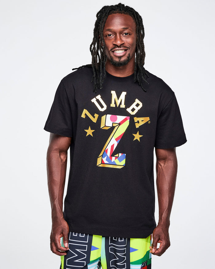 Male model wearing a black Zumba t-shirt with colorful design on a white background.