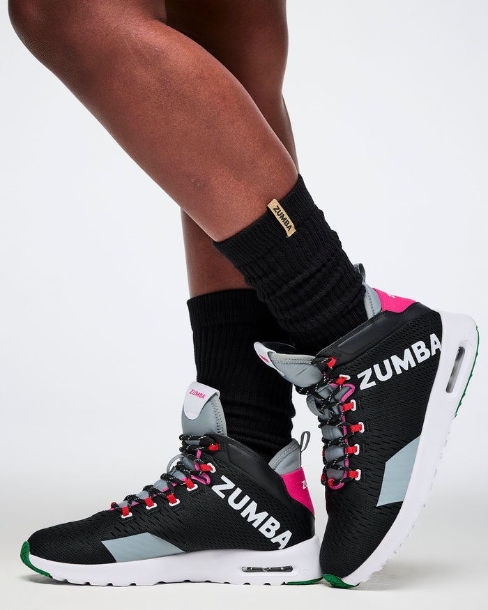 Zumba shoes worn with black socks on a white background.