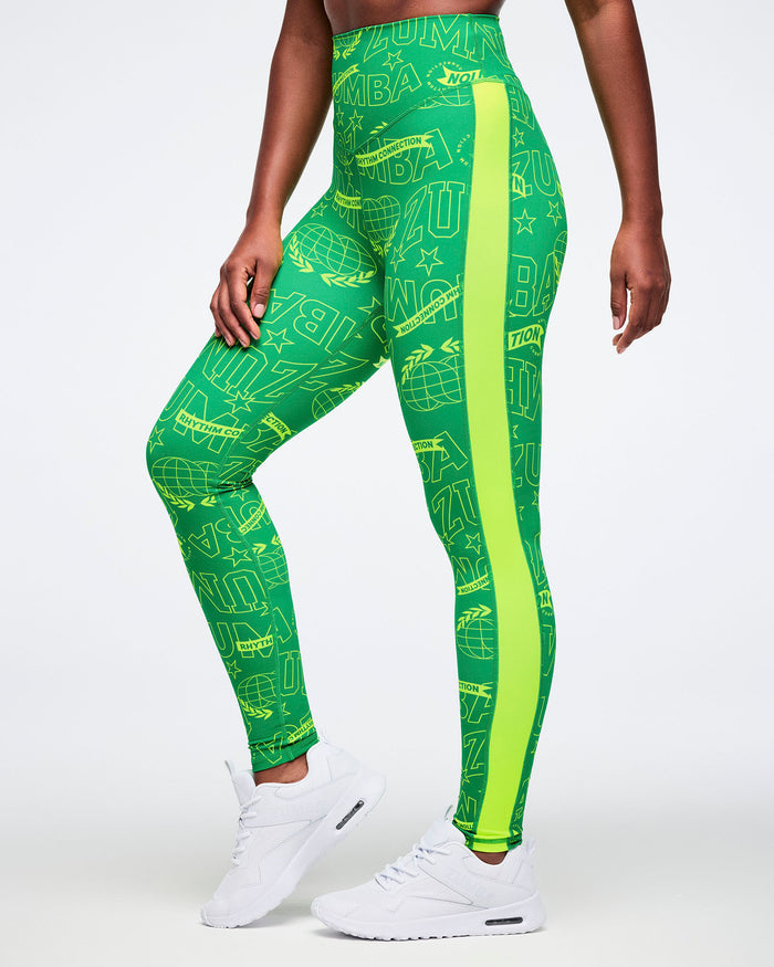 Female model wearing green leggings with a Zumba pattern and yellow stripe on a white background.