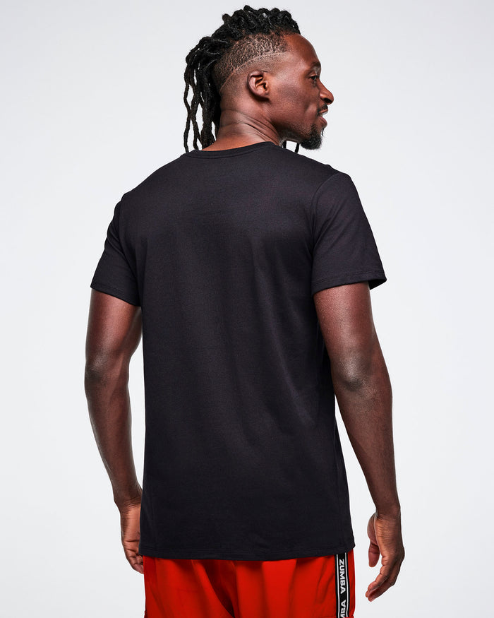 Back view of a male model wearing a black t-shirt and red pants on a white background.
