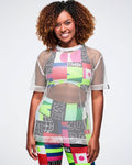 Female model wearing a colorful patterned bra and biker shorts, layered with a silver mesh top.