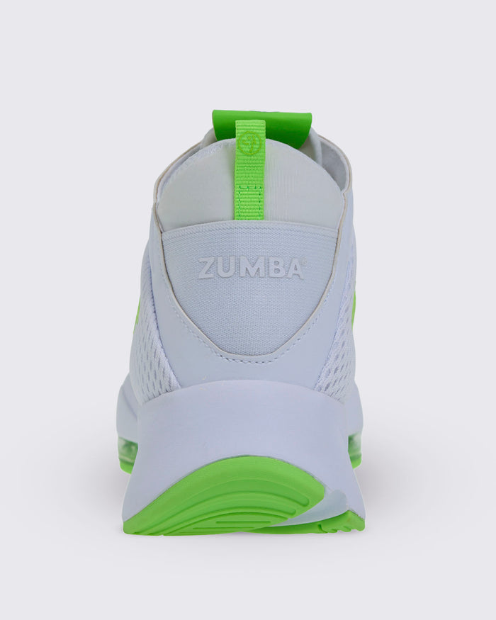 Back view of a white Zumba sneaker, showcasing a neon green heel pull tab, embossed “ZUMBA” at the back, and a green-accented outsole.