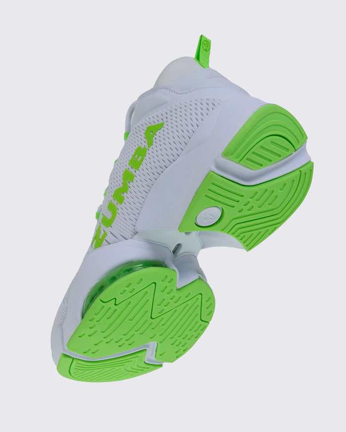 White and green sneaker viewed from a bottom angle, on a light gray background