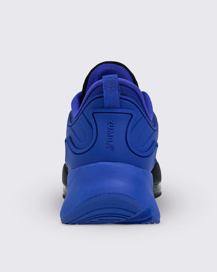 Rear view of blue Zumba sneaker with heel pull loop and embossed vertical "ZUMBA" branding in blue.