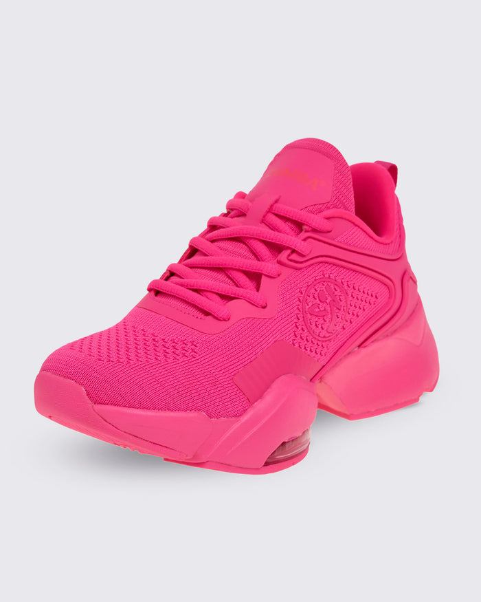 A pink shoe with a pink Zumbito on a white background.