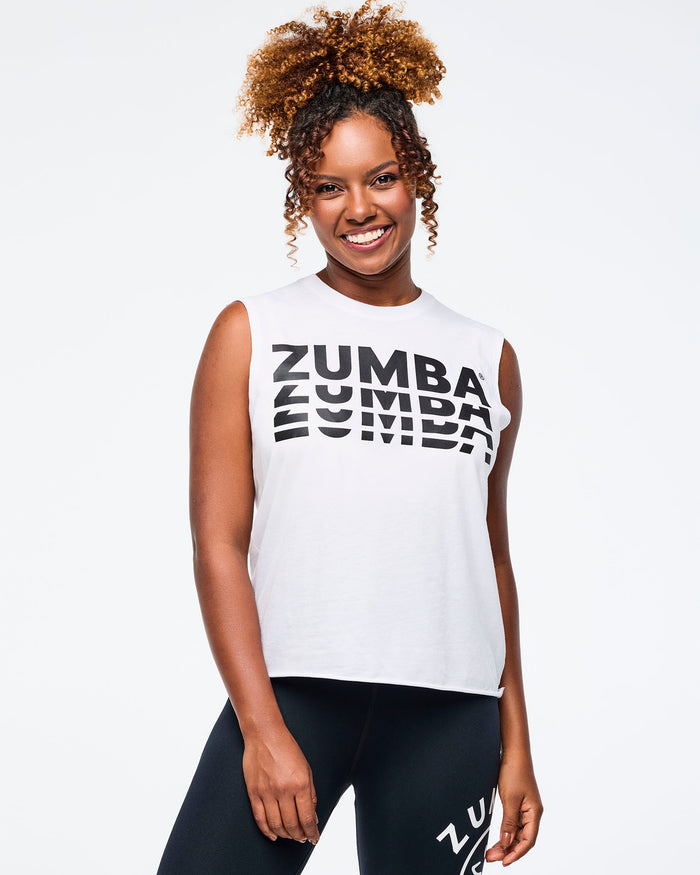 Female model wearing a Zumba sleeveless tank and leggings on a white background.