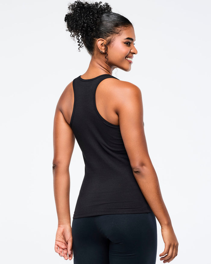 Back view of a female model wearing a black Zumba tank on a white background.