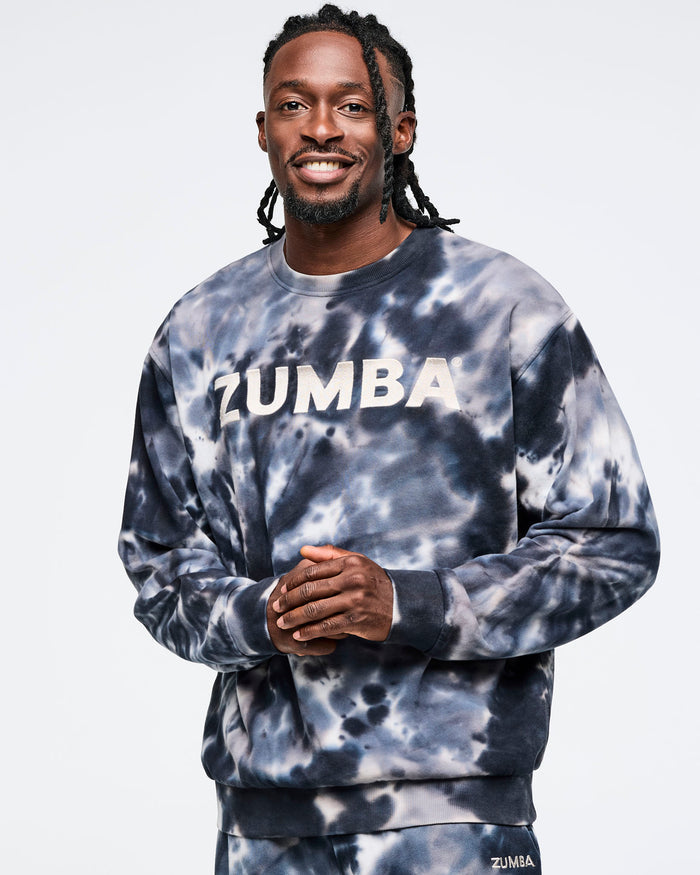 Male model wearing a Zumba tie-dye sweatshirt on a light gray background.