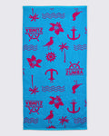 Turquoise beach towel with hot-pink Zumba logo and allover nautical icons, including anchors, palm trees, waves, flowers, and birds, laid flat on a white background.