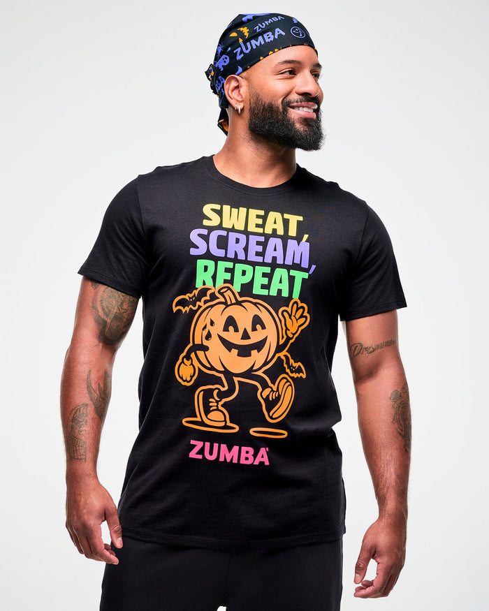 Male model wearing a black and purple Halloween bandana as a headwrap with a black "Sweat, Scream, Repeat" tee featuring a pumpkin graphic and "ZUMBA" in pink text.