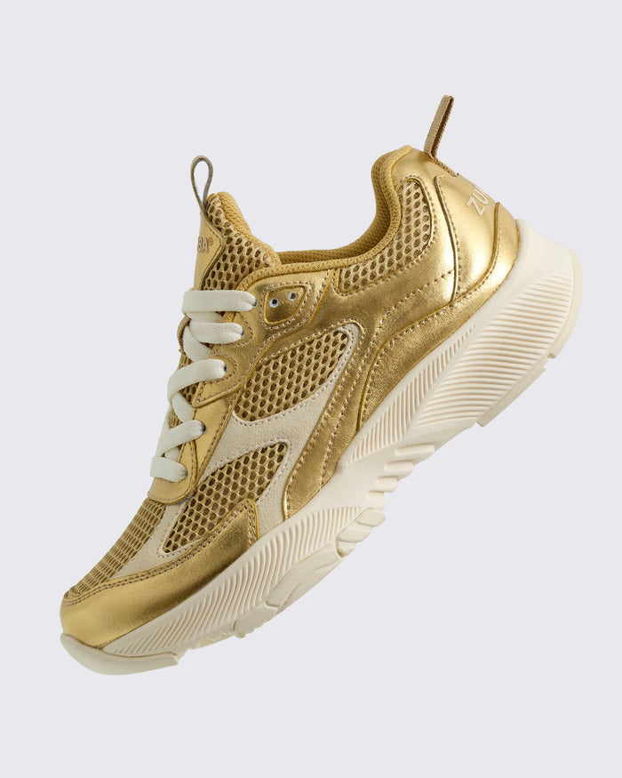 Angled view of the gold and beige bottom sneaker on a light background.