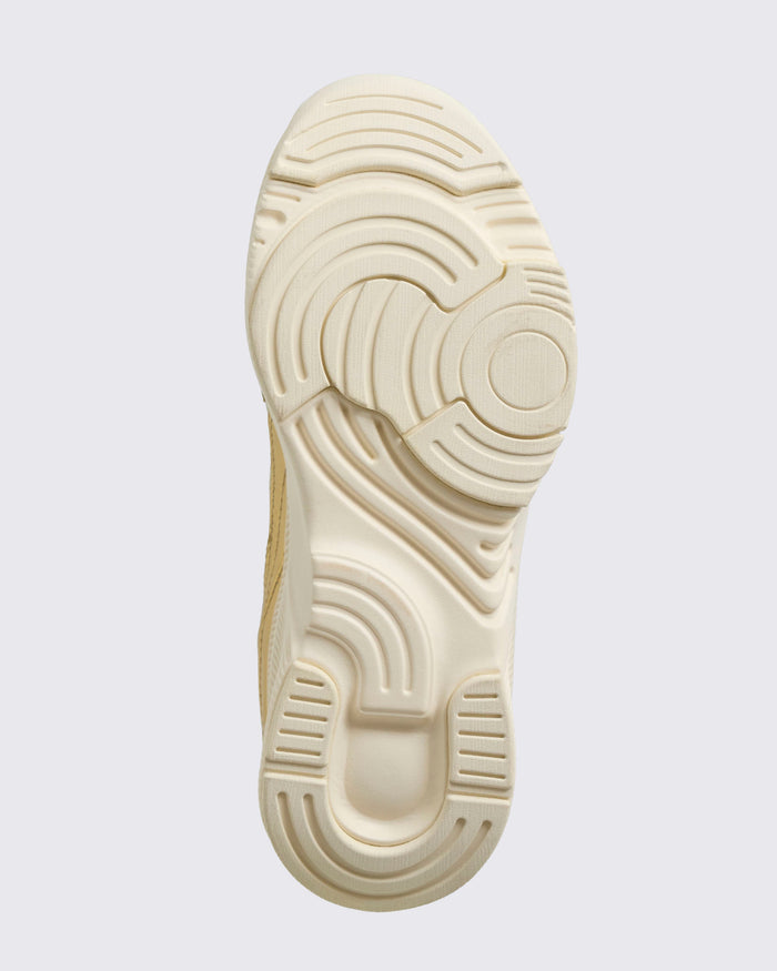 Close-up sole view of the white / beige shoe sole on a light background.