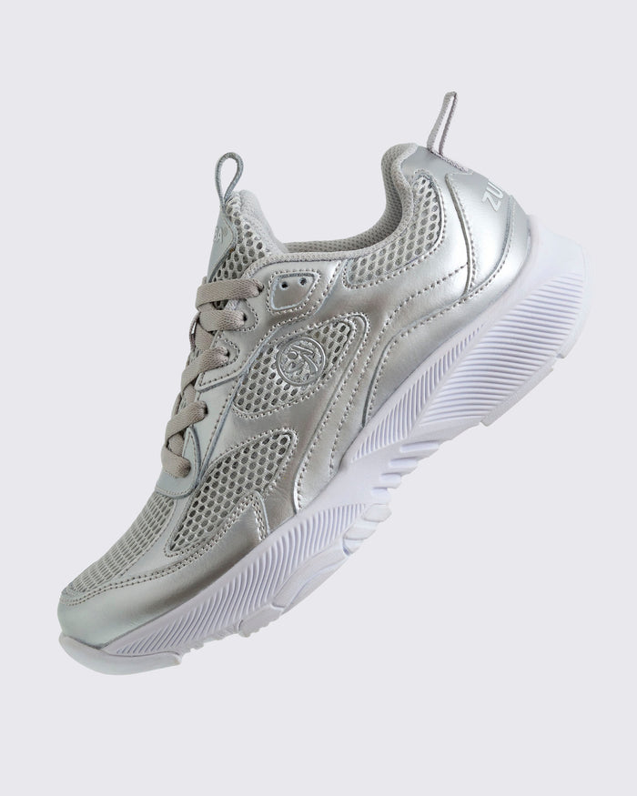 Silver Zumba athletic shoe, shown at a left angle and with a small silver Zumbito.