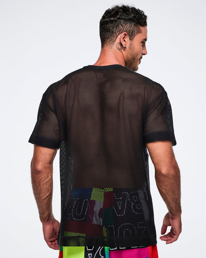 Back view of a male model wearing a black Zumba mesh shirt with colorful letters on a plain background.